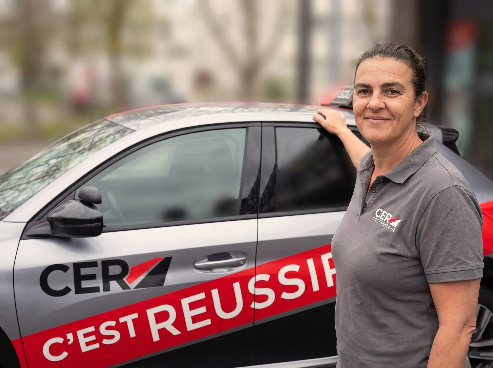 Véronique, enseignante, devant une voiture-école CER Rouen Normandie