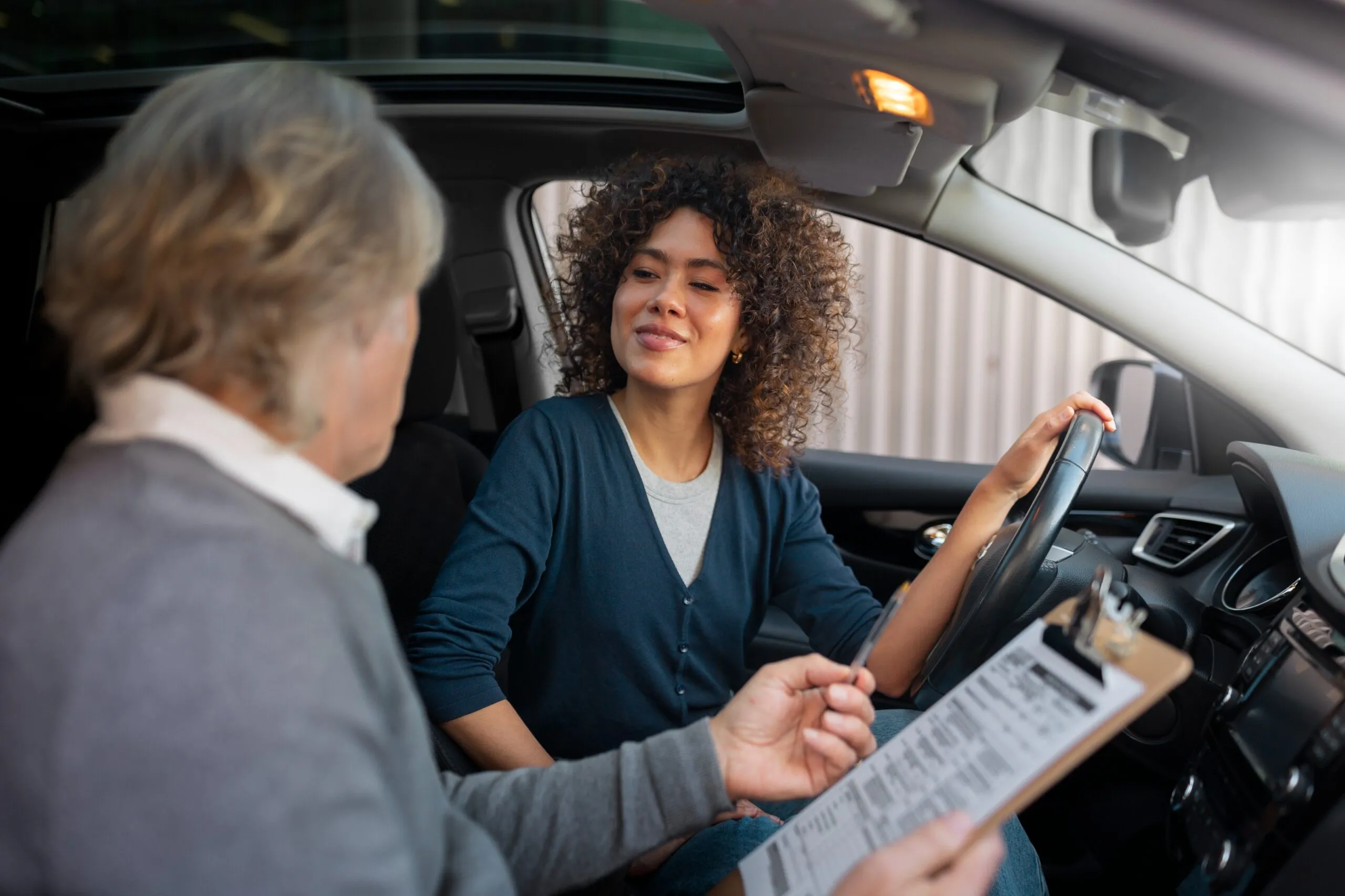 Une élève souriante au volant, lors d’une leçon de conduite
